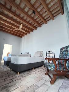 a bedroom with a large bed and a chair at Casa Privada in Vejer de la Frontera