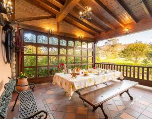 a screened in porch with a table and a bench at Casa Grau in Llanes