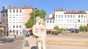 a statue in the middle of a street with buildings at Studio Croix Rousse in Lyon