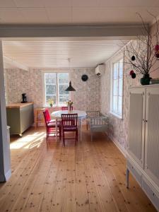 a kitchen and dining room with a table and chairs at Enskilda stugan in Kärsta