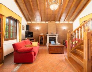 a living room with a red chair and a fireplace at Casa Grau in Llanes