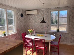 a kitchen with a table and chairs and windows at Enskilda stugan in Kärsta +10 photos