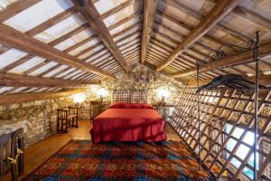 a bedroom with a red bed in a room with wooden ceilings at Tenuta Donna Vittoria in Trapani