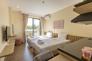 a hotel room with two beds and a television at Cham Charm Home Mui Ne in Ấp Thiện Phước