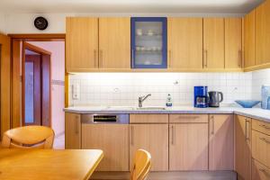 a kitchen with wooden cabinets and a wooden table at Schornhof in Oberwolfach