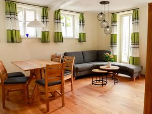 a living room with a couch and a table and chairs at Biobauer Heubach in Iphofen
