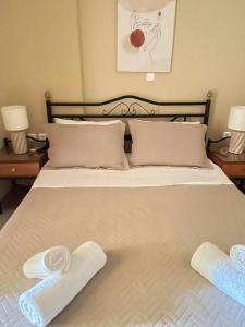a large white bed with two towels on it at Villas Kavouri in Kryonéri