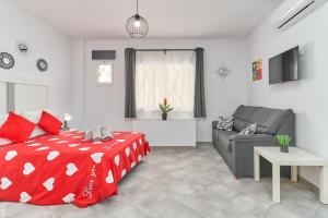 a bedroom with a red bed and a couch at Nerja Boutique B2 Street level in Nerja +16 photos