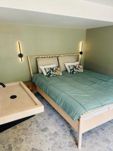 a bed with two pillows and a table in a room at Between hills and home in Trooz