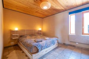 a bedroom with a bed in a room with two windows at Maison Time-out in Villevieille