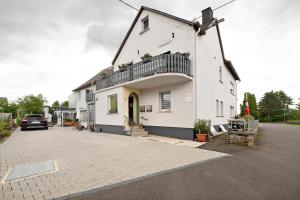a white house with a windmill on a street at Picco 1 in Beuren