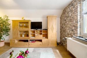 a living room with a tv and a stone wall at Picco 1 in Beuren