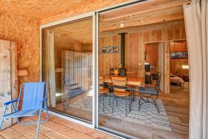 a room with glass doors and a table and chairs at Maison - Le pic du midi in Roquefeuil