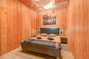 a bedroom with a bed in a wooden wall at Maison - Le pic du midi in Roquefeuil