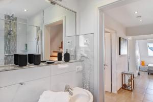 a white bathroom with a sink and a mirror at Villa Seebrise in Göhren-Lebbin +20 photos