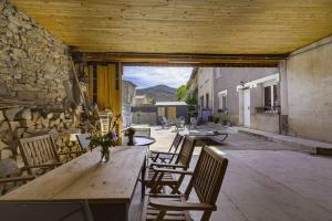 a wooden table and chairs on a patio at Maison - Le pic du midi in Roquefeuil