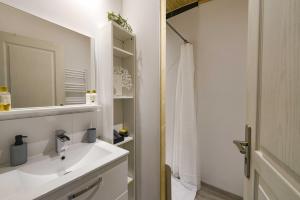 a white bathroom with a sink and a mirror at Maison - Le pic du midi in Roquefeuil +16 photos