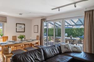 a living room with a leather couch and a table at Villa Seebrise in Göhren-Lebbin