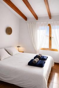 a bedroom with a large white bed with a window at Apartamento Natalia in Menorca +18 photos