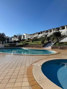 a swimming pool in a resort with a building in the background at Apartamento Natalia in Menorca