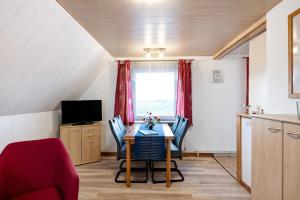a dining room with a table and chairs and a television at Bauernhof Angelika Schulze Pellworm in Pellworm