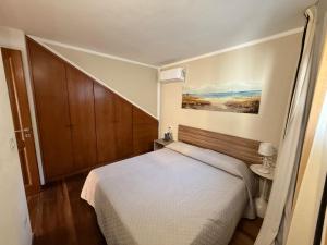 a small bedroom with a bed and a wooden cabinet at Sardinia house with beautiful view near sea in Brunella +55 photos
