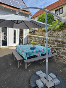 a table with an umbrella on a patio at Vogelsberger Bett Köddingen in Köddingen