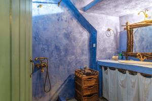 a blue bathroom with a sink and a mirror at Olive Guesthouse near farm in Fállika