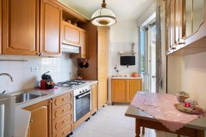 a kitchen with wooden cabinets and a sink and a table at La Ca' Di Marì in Costarainera