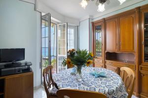 a dining room with a table with a vase of flowers on it at La Ca' Di Marì in Costarainera