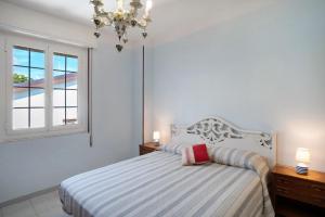 a bedroom with a bed and a window and a chandelier at La Ca' Di Marì in Costarainera
