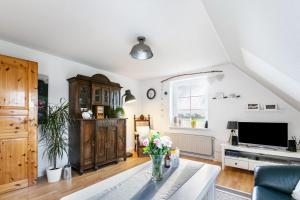 a living room with a vase of flowers on a table at Ferienwohnung Freiblick in Neukirchen +24 photos