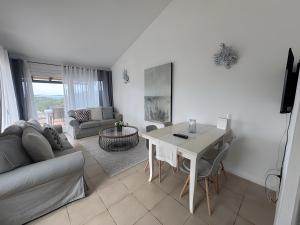 a living room with a table and a couch at Appartamento Sea View in Baja Sardinia
