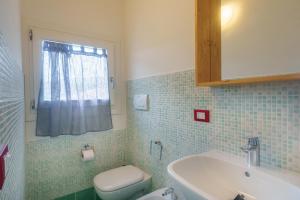 a bathroom with a white sink and a toilet at Appartamento Sea View in Baja Sardinia +14 photos