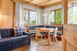 a living room with a couch and a table and chairs at Villa Nussbaumer in Siusi