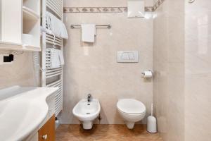 a white bathroom with a toilet and a sink at Villa Nussbaumer in Siusi +45 photos