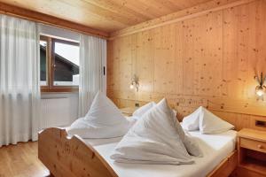 two beds in a room with wooden walls at Villa Nussbaumer in Siusi
