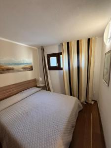 a bedroom with a white bed and a window at Sardinia house with beautiful view near sea in Brunella