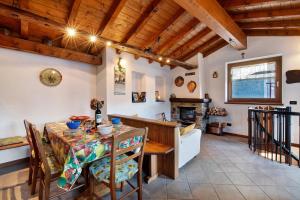 a dining room with a table and chairs and a fireplace at Baita Margherita in Casargo +13 photos