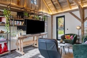 a living room with a flat screen tv on a wooden wall at Ferienhaus Buwesch 13 in Nüsttal