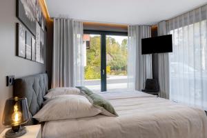 a bedroom with a bed and a large window at Ferienhaus Buwesch 13 in Nüsttal