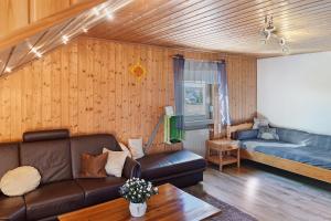 a living room with a couch and a bed at Fewo Tanja's Blumenparadies in Hollfeld
