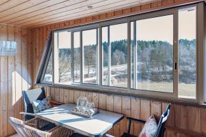 a table and chairs in a room with windows at Fewo Tanja's Blumenparadies in Hollfeld