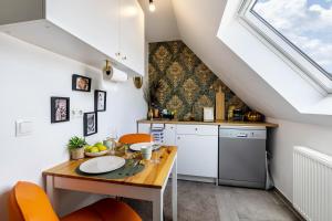 a kitchen with a wooden table and orange chairs at Deluxe Apartment in Duisburg