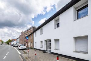 a white building on the side of a street at Deluxe Apartment in Duisburg