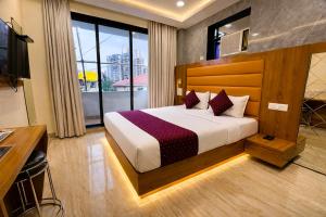 a bedroom with a bed and a large window at Hotel National - Grant Road in Mumbai