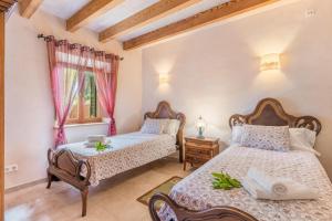 a bedroom with two beds and a window at Finca Son Palanca in Sineu +20 photos