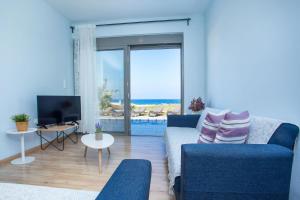 a living room with a blue couch and a view of the ocean at Rhodes Sea Villas No 2 in Ialysos