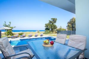 a table with a bowl of fruit on it next to a pool at Rhodes Sea Villas No 2 in Ialysos