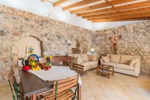 a living room with a table and a stone wall at Finca Son Palanca in Sineu